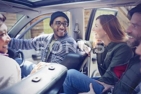 Smiling friends talking and riding in car Stock Photos