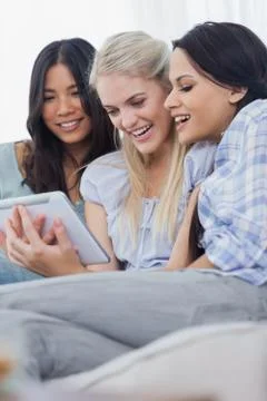 Smiling friends using digital tablet together Stock Photos