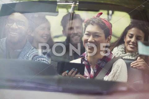 Smiling friends using GPS on smart phone riding in car Stock Photos