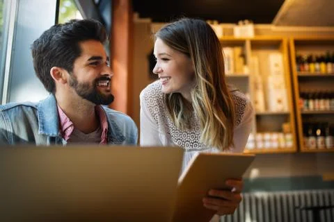 Smiling friends using notebook in cafe at the university Stock Photos