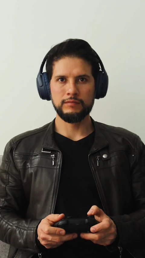A smiling gamer man playing with a wireless controller in a competitive attitude Vídeo Stock 340583516