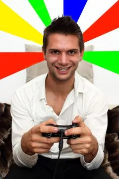 Smiling gamer sitting on couch with controller and playing Stock Photos