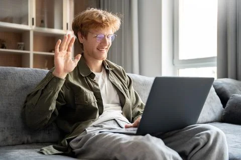 Smiling ginger irish man having video call over laptop computer at home Stock Photos