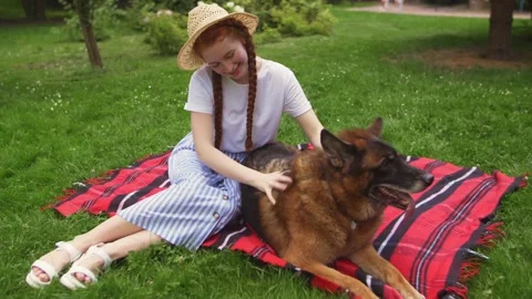 Smiling ginger lady taking free time with her dog. Woman relaxing in the nature Stock Footage 142329784