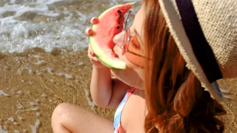 Smiling girl on the beach posing with two slices of watermelon Stock Footage 95877684