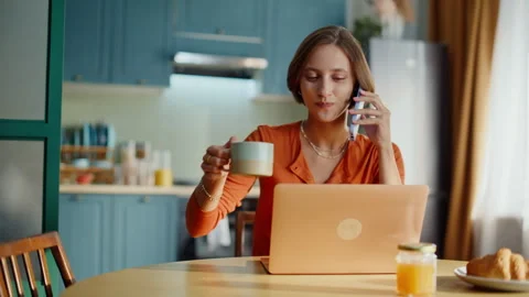 Smiling girl calling cellphone drinking coffee at breakfast closeup. Happy woman Stock Footage 333775851