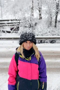 Smiling girl in pink ski jacket and hat with snow Stock Photos