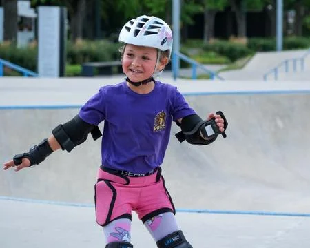 Smiling Girl Practicing Inline Skating at Skatepark Stock Photos