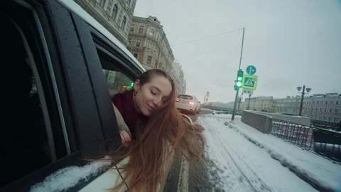Smiling girl pull out head out of the car window into street in St. Petersburg Stock Footage 247667293