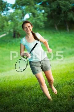 Smiling girl with a racket for a badminton in the park Stock Photos