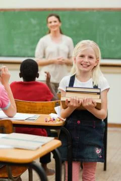 Smiling girl with stack of books Stockfoto's