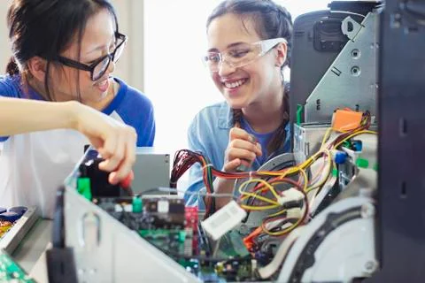 Smiling girl students assembling computer in classroom Stock Photos