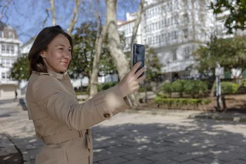 A smiling girl takes a selfie in the park. Stock Photos