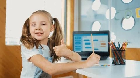 Smiling girl using laptop while look and show thumb up to camera. Erudition. Stock Photos