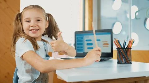 Smiling girl using laptop while look and show thumb up to camera. Erudition. Stock Photos