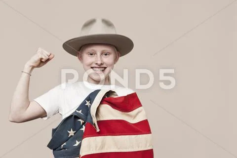 A smiling girl wearing a ranger hat wrapped in an American flag and making a Stock-Fotos