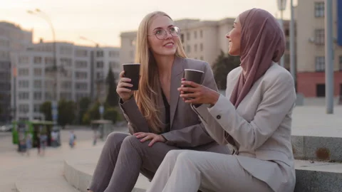 Smiling girlfriends drinking coffee, diverse female colleague in formal business Stock Footage 202264235