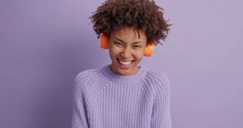 Smiling glad dark skinned young woman with curly hair feels very happy wears Stock Footage 144455670