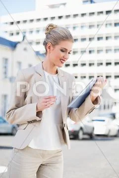 Smiling gorgeous businesswoman using tablet pc Stock Photos