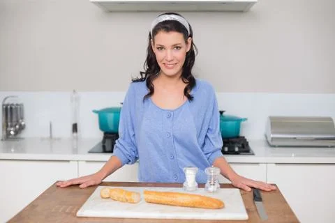 Smiling gorgeous model cutting bread 스톡 사진