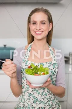 Smiling gorgeous model holding salad bowl Stock Photos