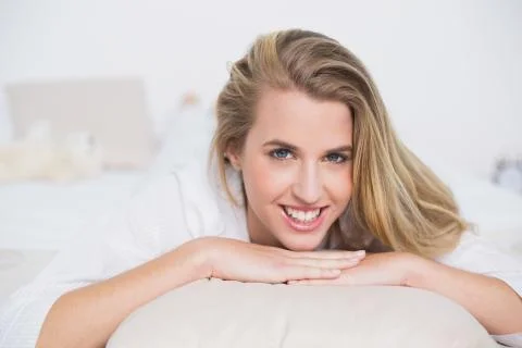 Smiling gorgeous model lying on her bed Stock Photos