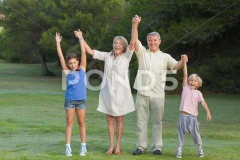 Smiling grandparents standing with their grandchildren cheering Stock Photos