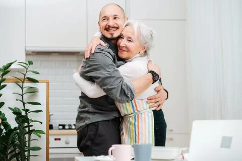 Smiling granny hugging her son like they didn't see each other for a long tim Stock Photos