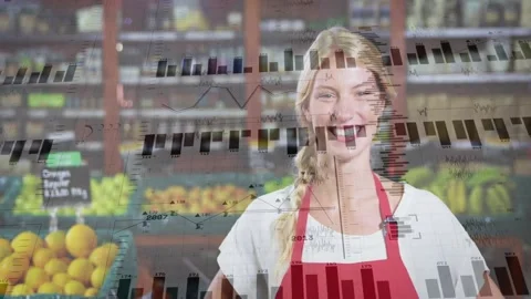 Smiling grocer in red apron posing at produce section with citrus, charts, lapel Stock Footage 331161015