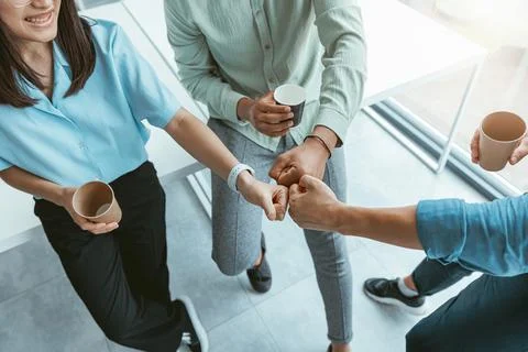 Smiling group of multiethnic colleagues drinking coffee and talking during break Stock Photos