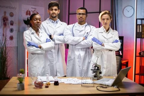 Smiling group of scientists in modern laboratory with male african american Stock Photos