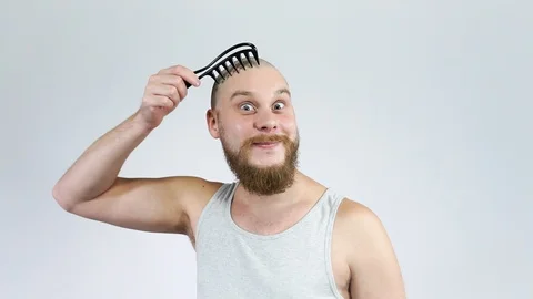 The smiling guy with the beard combing his bald head and smiling Stock Footage 122005544