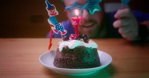 Smiling Guy Blowing Out Candle On a Delicious Birthday Cake a Big Celebration Stock Footage 144005249