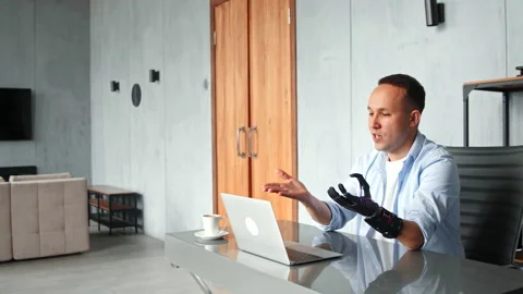 Smiling guy describes bio hand prothesis and gesticulates Stock Footage 157330494