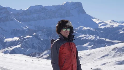 Smiling guy in a funny hat in the snowy mountains Stock Footage 87793285