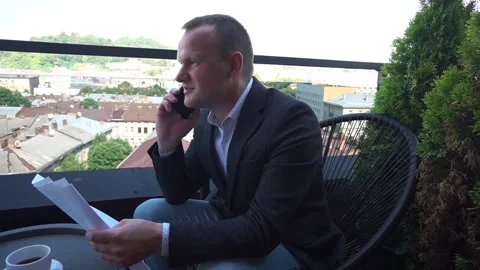 Smiling guy in jacket close up in focus sitting and speaking on mobile. Male Stock Footage 160553295