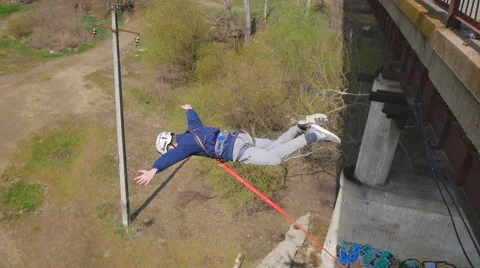 Smiling guy jumping from the bridge facing forward Stock Footage 68347267