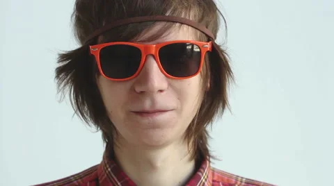 A smiling guy puts on orange sun glasses Video stock 45440753