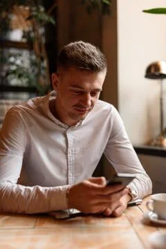 Smiling guy is reading message on smartphone Foto stock