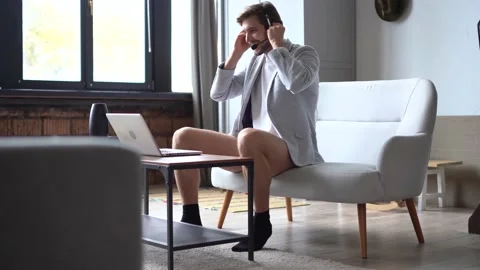 Smiling handsome freelancer working remotely from home, dressed only in a shirt Stock Footage 142873980