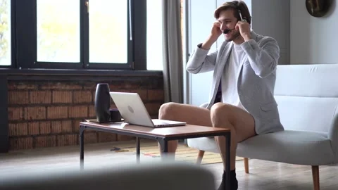 Smiling handsome freelancer working remotely from home, dressed only in a shirt Stock Footage 142874030