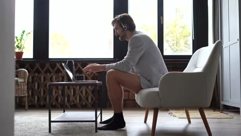 Smiling handsome freelancer working remotely from home, dressed only in a shirt Stock Footage 142874051