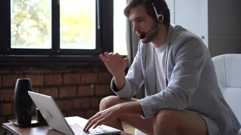 Smiling handsome freelancer working remotely from home, dressed only in a shirt Vídeos de archivo 142874082