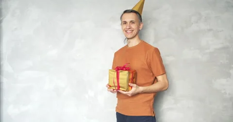 Smiling handsome man looking at the camera and giving a gift box Stock Footage 134612249