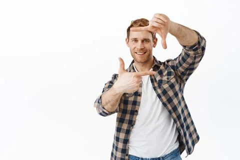 Smiling handsome redhead guy making hand frames, camera gesture and take picture Stock Photos