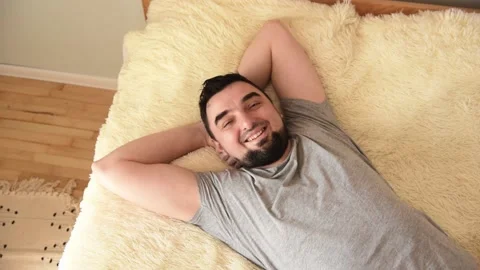 Smiling handsome young man lying on the bed. Home concept Video stock 152258482
