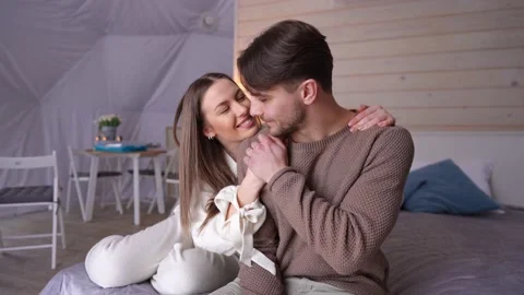 Smiling handsome young man stroking hand of loving woman kissing fingers sitting Vidéo 227502060