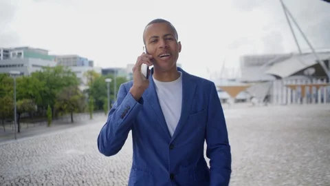 Smiling handsome young man talking on phone while walking. Stock Footage 107801730