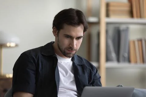 Smiling handsome young man using computer at home. Foto stock