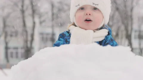 Smiling happy child makes big snowball outside during snowfall. Video stock 211694121
